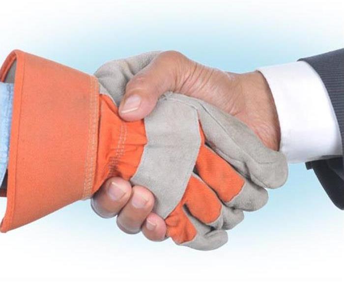 hand in work glove and hand in suit shaking hands