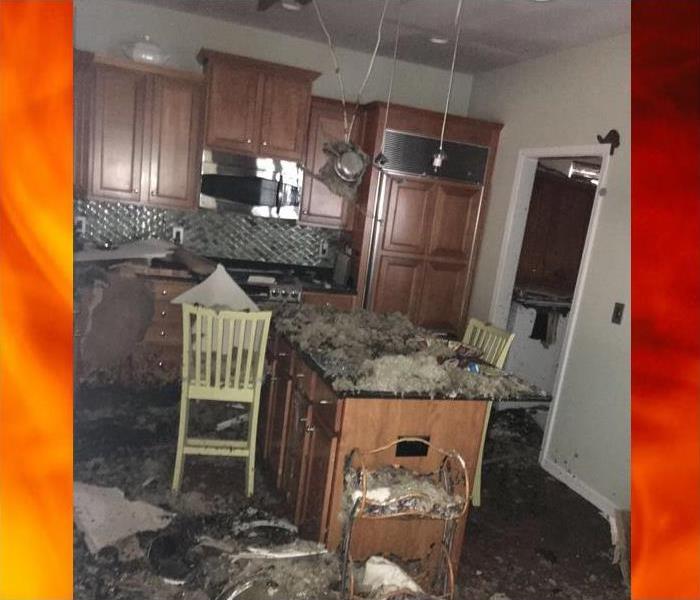Kitchen with ceiling and insulation caved in after a fire damage